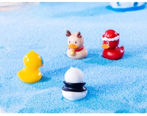 Miniature resin duck set featuring Christmas santa, reindeer and panda styles on blue sand