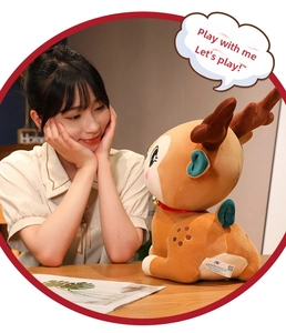 Close-up of cute plush reindeer with a golden bell and red ribbon around its neck
