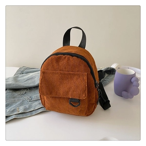 Detail view of caramel corduroy backpack featuring front pocket and D-ring detail