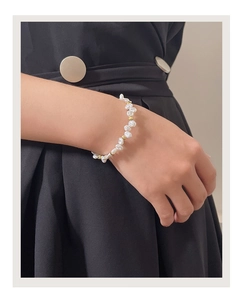 Detail of baroque pearl bracelet with gold beads on wrist for an elegant vintage look