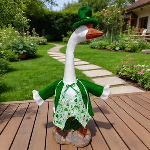 Detail of a resin garden goose statue in St. Patrick's Day green outfit on a wooden deck