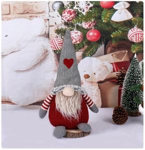 Dettaglio dello gnomo natalizio in maglia rosso e grigio con cuore su base in legno
