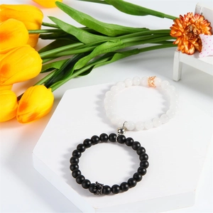 Close-up of magnetic natural agate bead bracelets with crown charms on a display stand
