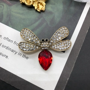 Elegant gold dragonfly brooch with red teardrop crystal and sparkling rhinestones