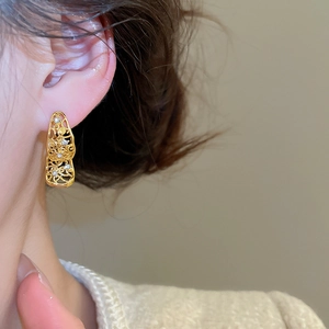 Détail de boucles d'oreilles vintage dorées avec diamants en forme de goutte sur un modèle