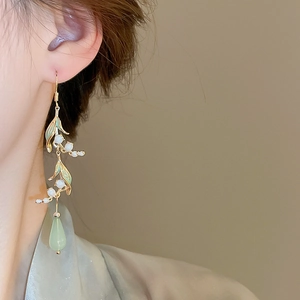 Detail of Lily of the Valley drop earring with green enamel leaves and teardrop resin