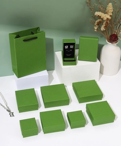 Macro view of grass green minimalist jewelry boxes and matching gift bags in various sizes