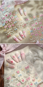 Détail macro de stickers ongles 3D avec nœuds en dentelle et motifs de cœurs roses