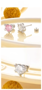 Detail of heart-shaped zircon earrings with secure screw back design in silver finish