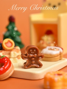 Macro di un omino di pan di zenzero in resina e miniatura di ciambella natalizia decorata