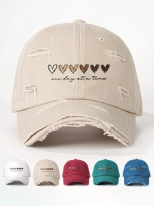 Detail view of heart embroidery and distressed vintage texture on washed baseball cap