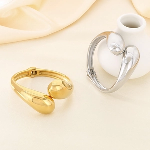 Modern irregular cross-open cuff bracelet in polished gold and silver finishes