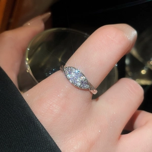 Macro shot of silver marquise zircon flower ring on finger with elegant bokeh effect