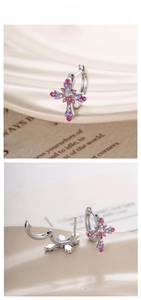 Close-up of bohemian cross hoop earrings with pink and purple crystal pavé setting
