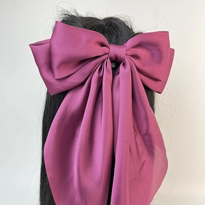 Grande pince à cheveux en satin violet avec nœud et longs rubans fluides élégants.