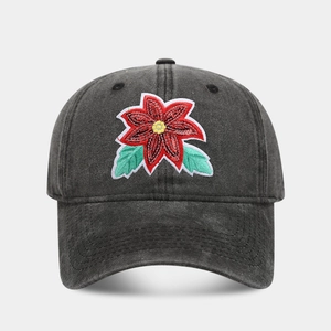 Close-up of red flower embroidery on a vintage washed black cotton baseball cap
