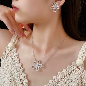 Détail d'un ensemble de bijoux fleur argentée avec zircons portés par un mannequin