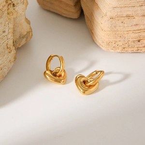 Vista macro degli orecchini a cuore placcati oro 18K lucido su base in pietra naturale