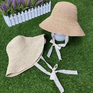 Close-up of woven straw sun hat featuring delicate white lace ribbon and fine texture