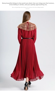Detail of red pleated chiffon maxi dress featuring golden sequin embroidery on the shawl