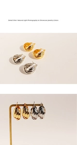 Macro shot of chunky twisted hoop earrings showing mirror polished gold and silver finish