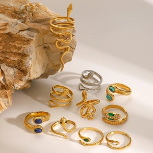 Detailed close-up of snake rings with turquoise and zircon on natural stone backdrop