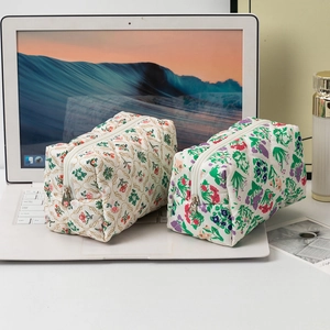 Quilted cotton floral makeup bags for travel with zipper closure on white laptop