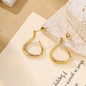 Macro detail of teardrop twisted gold earrings with a high-polished mirror finish