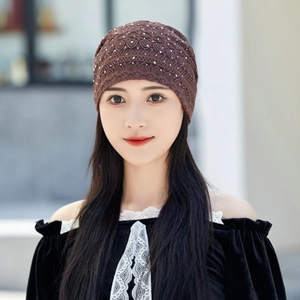 Close-up of brown lace beanie featuring hollow-out floral patterns and soft texture