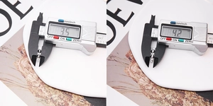 Macro view showing 3.5mm and 4.2mm S925 sterling silver crimp bead covers with a caliper