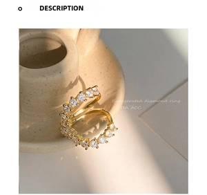 Detailed macro view of S-shaped open ring in gold finish with micro-set crystals