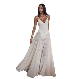 Detail of elegant beige mesh dress featuring a golden ring accessory on the shoulder strap