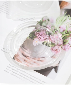 Macro detail of a tiered round transparent acrylic jewelry display tray on a floral magazine