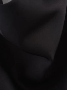 Vue macro détaillée du tissu satin noir montrant la texture dense et le drapé élégant