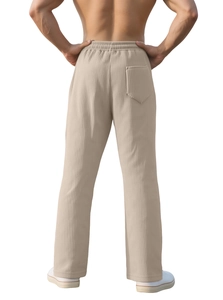 Detail of men's vertical striped khaki trousers featuring elastic waist and back pocket