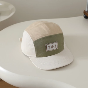 Dettaglio del cappellino camper a cinque pannelli con patch TIDE e cuciture a contrasto