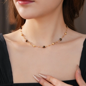 Dettaglio della collana con perle occhio di tigre placcata oro indossata dal modello