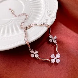 Elegant silver-toned clover bracelet with zircon stones on a white ceramic plate