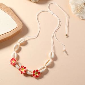 Détail macro d'un collier de coquillages avec fleurs de frangipanier tropicales