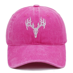 Close-up of deer skull embroidery on washed cotton rose red baseball cap texture