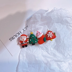 Close-up detail of festive Christmas hair clip featuring Santa Claus and tree charms