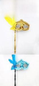 Detail of sequined masquerade masks with feathers and gems on handheld sticks