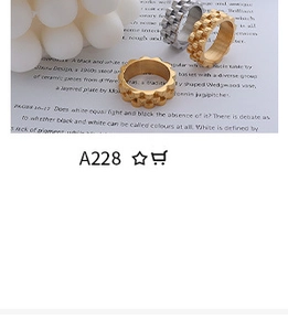 Detailed view of three minimalist gold and silver rings set against an aesthetic book backdrop