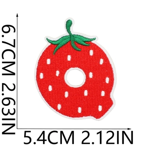 Detail of Q-shaped strawberry embroidery patch with size markers 6.7cm by 5.4cm