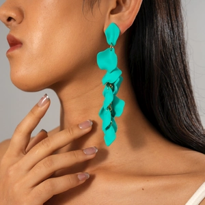Detail of teal matte acrylic petal drop earrings cascading with elegant golden rings