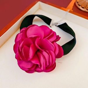 Detail of a large magenta fabric rose choker with a black velvet ribbon and silver clasp