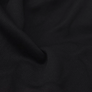 Macro shot of breathable black knit cotton fabric showing texture and elasticity