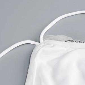 Detail of white halter dress featuring sequins, mesh embroidery and fine shoulder straps