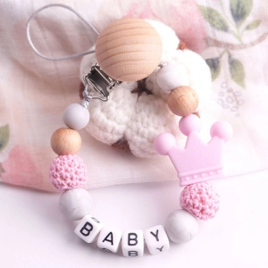 Detail of beechwood and pink silicone pacifier clip with crochet beads and crown charm