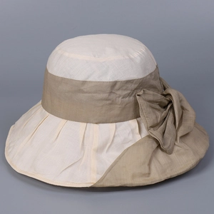 Detail of elegant sun hat showing the cream and khaki woven fabric with a large bow